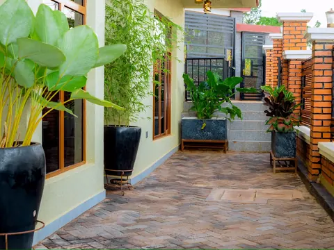 Tiled courtyard path with potted plants leading towards the gate