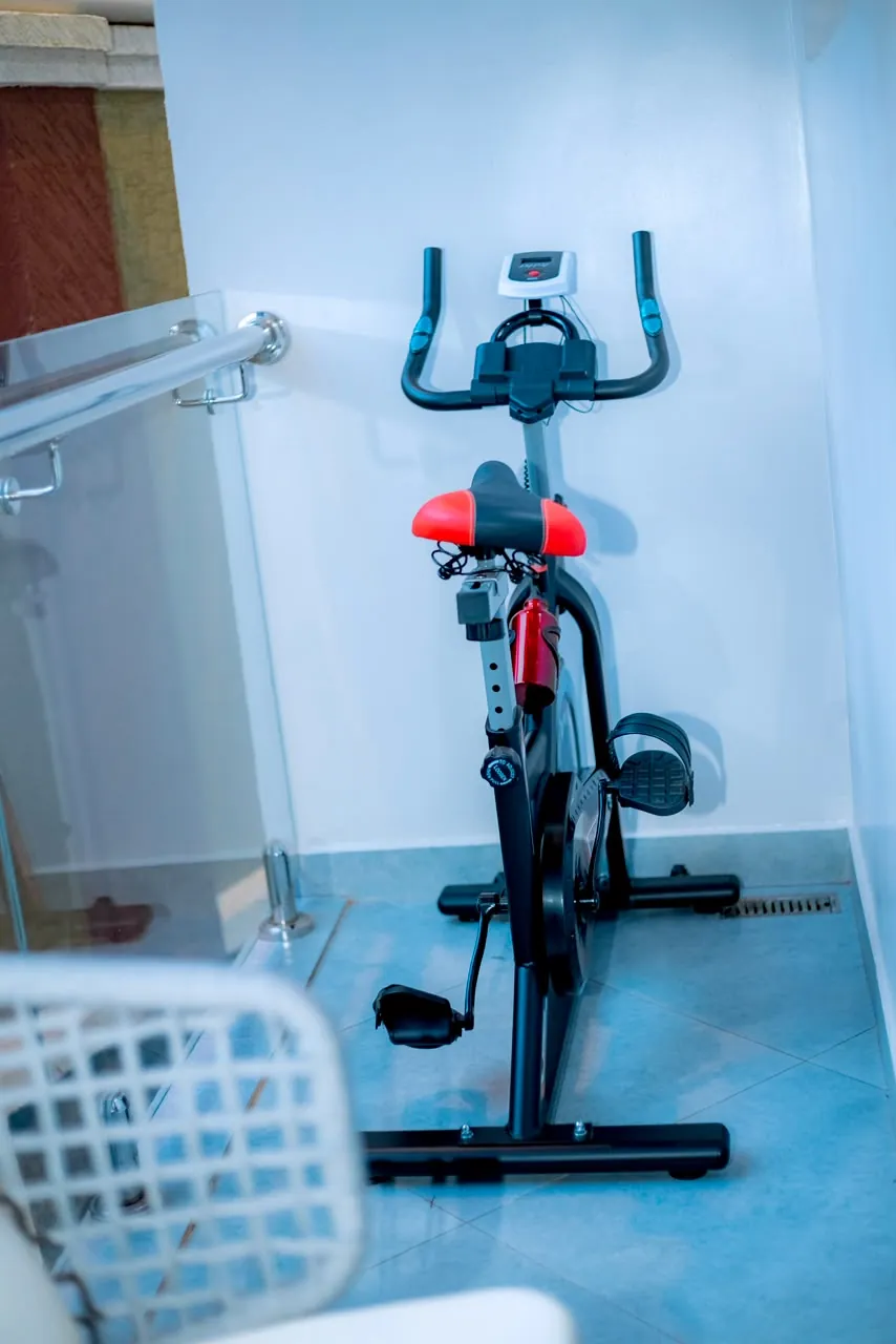 Indoor exercise bike with a red and black seat and black handlebars