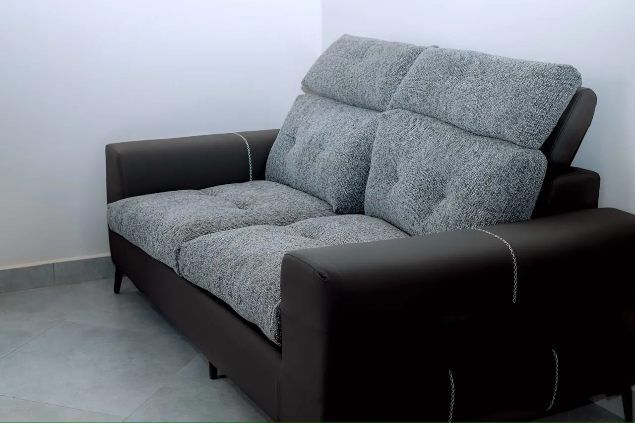 Two-seat gray upholstered sofa with dark armrests