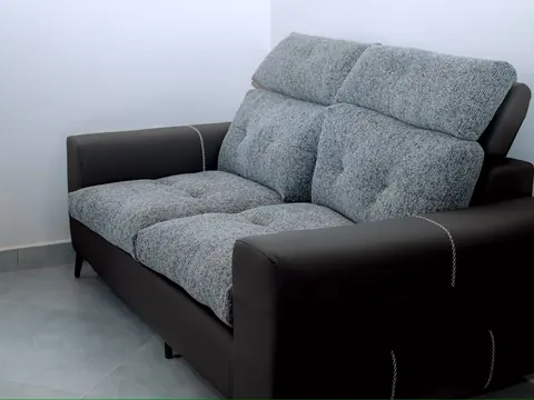 Two-seat gray upholstered sofa with dark armrests